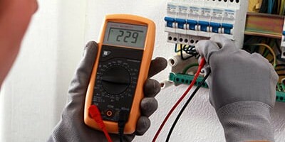 Image d'une électricienne contrôlant le compteur électrique