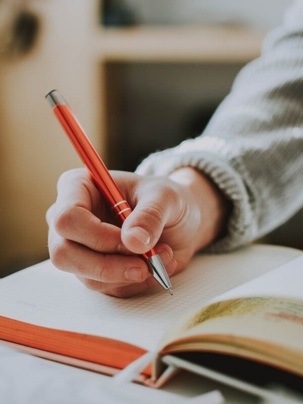 Image d'une étudiante qui prend des notes